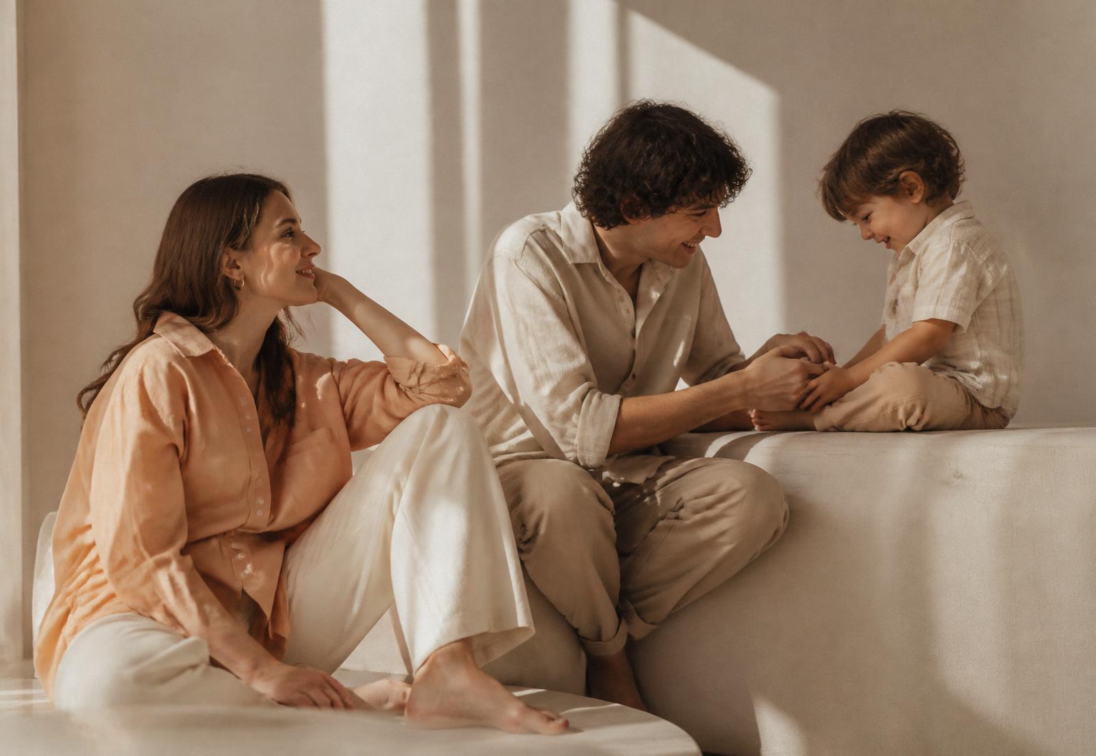 A family in soft apricot, cream and stone cotton essentials in warm afternoon light
